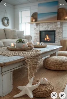 a living room filled with furniture and a fire place covered in blankets on top of a wooden table