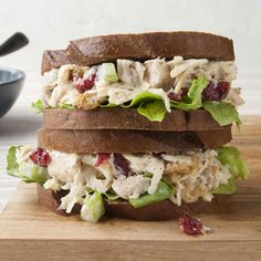 two sandwiches stacked on top of each other with lettuce and cranberries