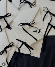 many white envelopes tied together with black ribbons