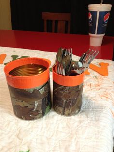 two cups with forks and spoons in them sitting on a table next to each other