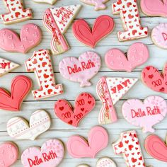 decorated cookies are arranged on a white wooden surface with the letters i - m and l