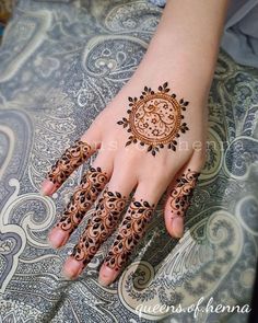 a woman's hand with henna tattoos on it