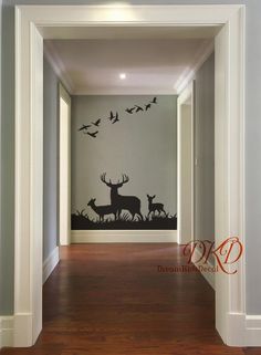 an empty hallway with deer and birds painted on the wall