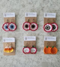 six pairs of crocheted earrings with eyeballs and pumpkins