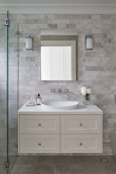 a white bathroom sink sitting under a mirror