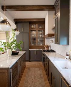 a kitchen with marble counter tops and wooden cabinets, along with an area rug on the floor