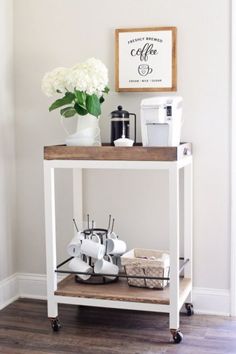 a white table topped with lots of items on top of a hard wood floor next to a wall