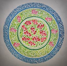 a colorful plate with flowers painted on the front and sides in blue, green, red and pink