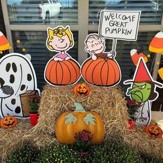 a display with pumpkins, hay bales and cartoon characters on the windowsill