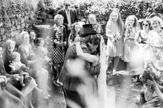 black and white photograph of wedding party with bride hugging the groom in front of them