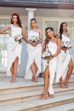 a group of women in white dresses standing on steps