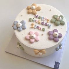 a white cake with flowers and the words happy birthday on it's frosting