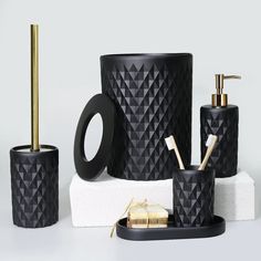 black bathroom accessories with gold accents on display