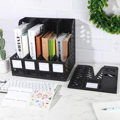 a desk with some books on it and a pen holder in front of the computer