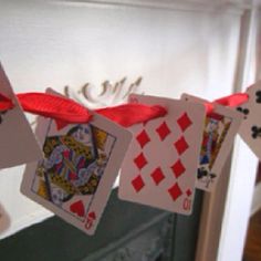 some cards are hanging on a clothes line with red ribbon and bow around the strings