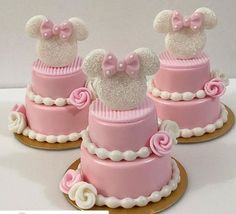 three pink and white cakes decorated with minnie mouse ears