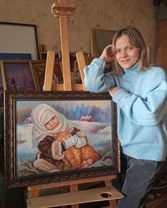 a woman standing next to an easel with a painting on it