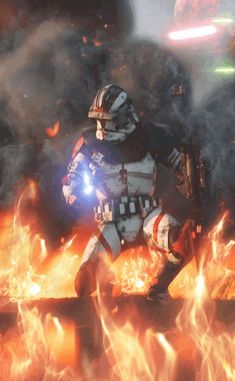 a star wars character standing in front of fire