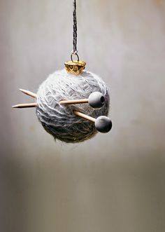 an ornament hanging from a string with needles sticking out of it's center