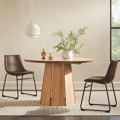 a dining room table with two chairs and a vase on the table next to it