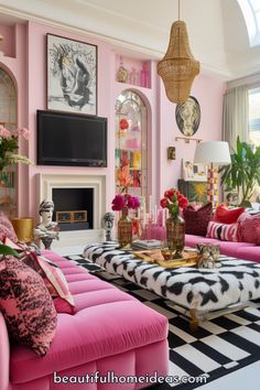 a living room with pink couches and black and white rug