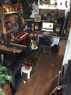 a room filled with lots of musical equipment and plants on top of the desks