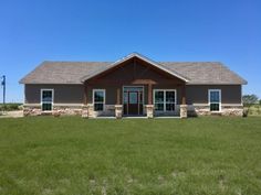 a large house sitting on top of a lush green field