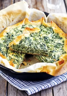 spinach and cheese quiche in a cast iron skillet on a wooden table