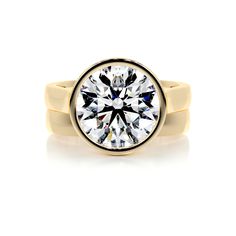 a yellow gold ring with a round brilliant cut diamond in the center, on a white background