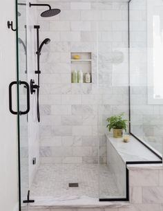 a walk in shower sitting next to a white bath tub under a bathroom window with black trim