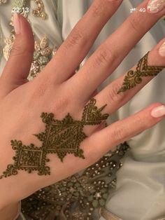 a woman's hand with henna tattoos on it