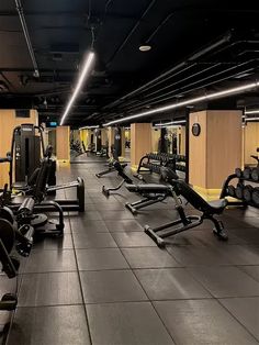 an empty gym with rows of exercise equipment and no people in the room or on the floor