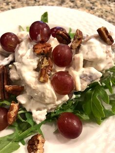 grapes and pecans are garnished with cream sauce on a white platter