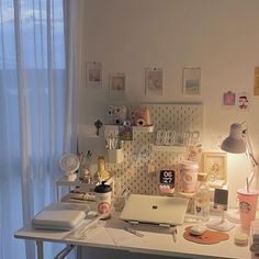 a desk with various items on it in front of a window