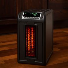 an electric space heater sitting on top of a wooden floor next to a wall