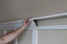 a man is working on an unfinished shelf