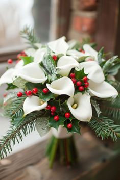 a bouquet of white flowers and greenery on a table