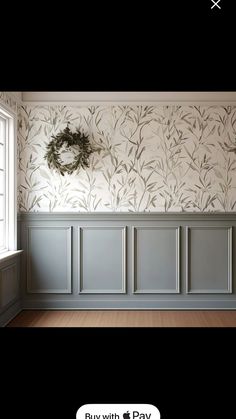 an empty room with wallpaper and a wreath on the window sill next to it