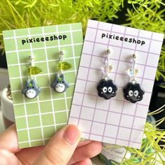 there are two earrings that have animals on them and the words pixieshop