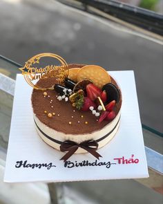 a birthday cake with chocolate frosting and strawberries