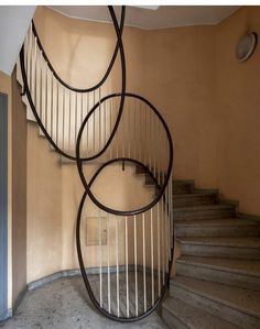 a spiral staircase in an empty room with no one around it or on the ground