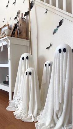 three white ghost statues sitting on top of a wooden floor