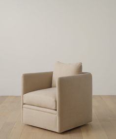 a beige chair sitting on top of a wooden floor