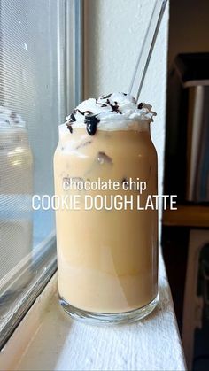 a cookie dough latte in a glass on a window sill