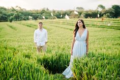 a man and woman standing in the middle of a field