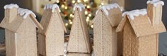 a group of wooden houses sitting on top of a table next to a christmas tree