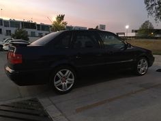 a black car is parked on the side of the road