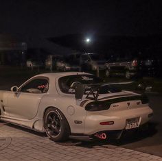 a white sports car parked on the street at night