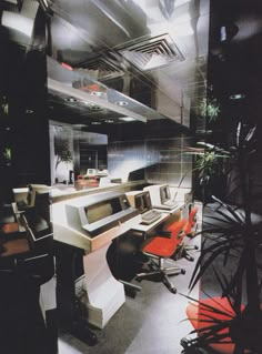 an office with multiple computers and red chairs