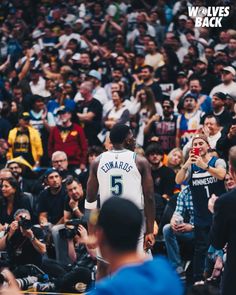 a man standing in front of a crowd holding a basketball